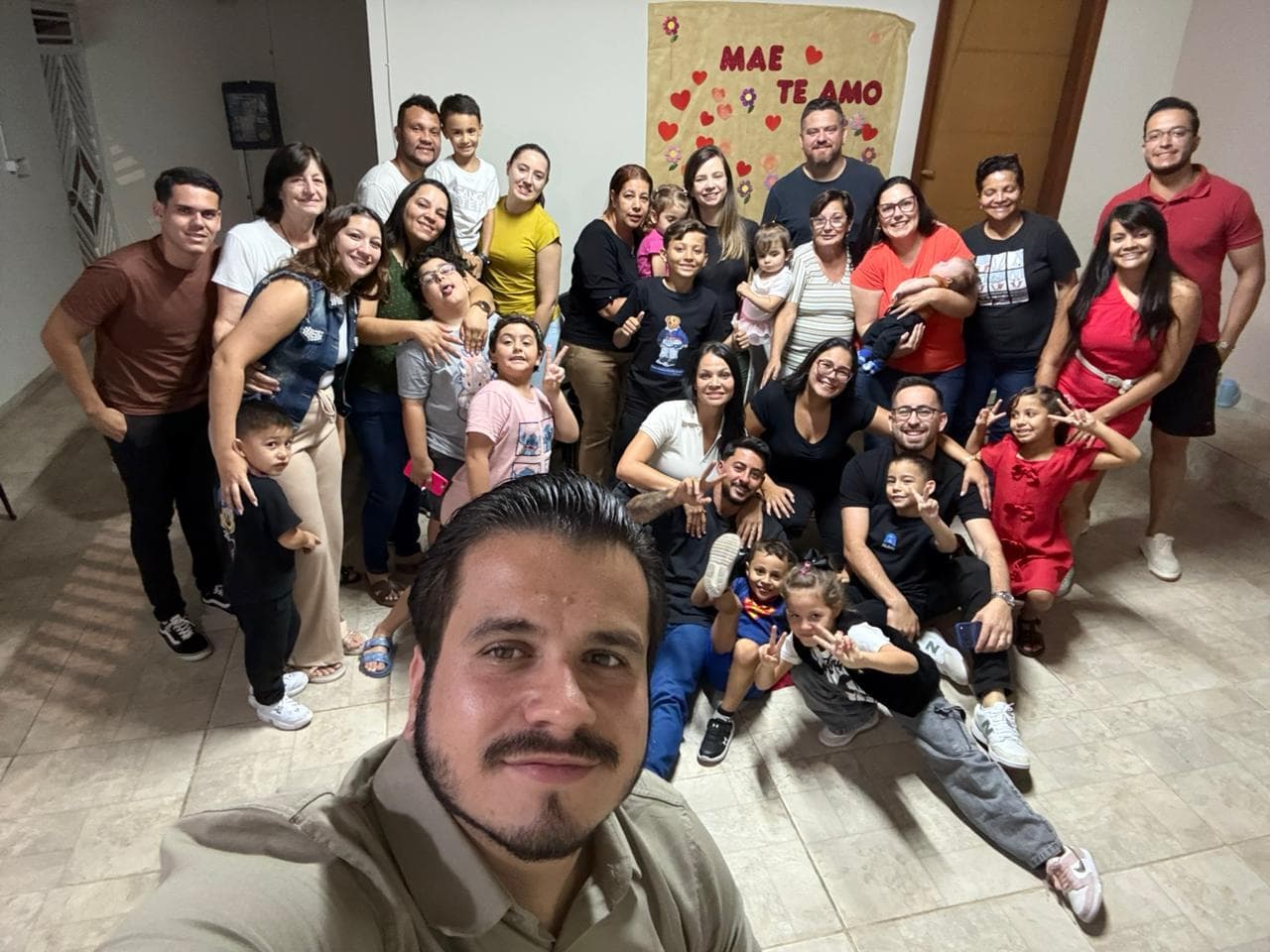 Célula reunida na sala de uma casa, adultos e crianças espremidos para caber na mesma foto