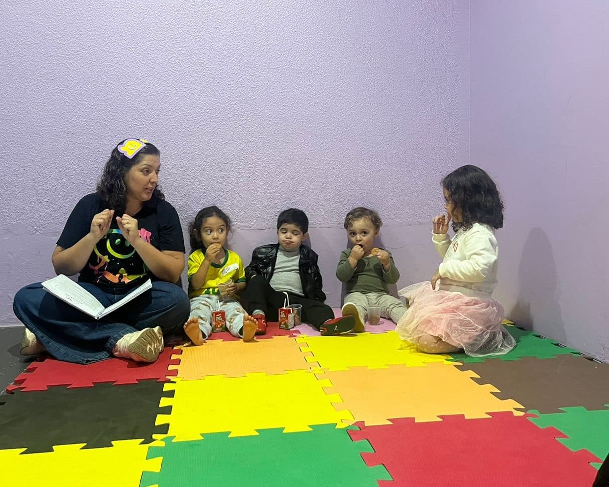 Líder com a Bíblia aberta ensinando um grupo de crianças pequenas