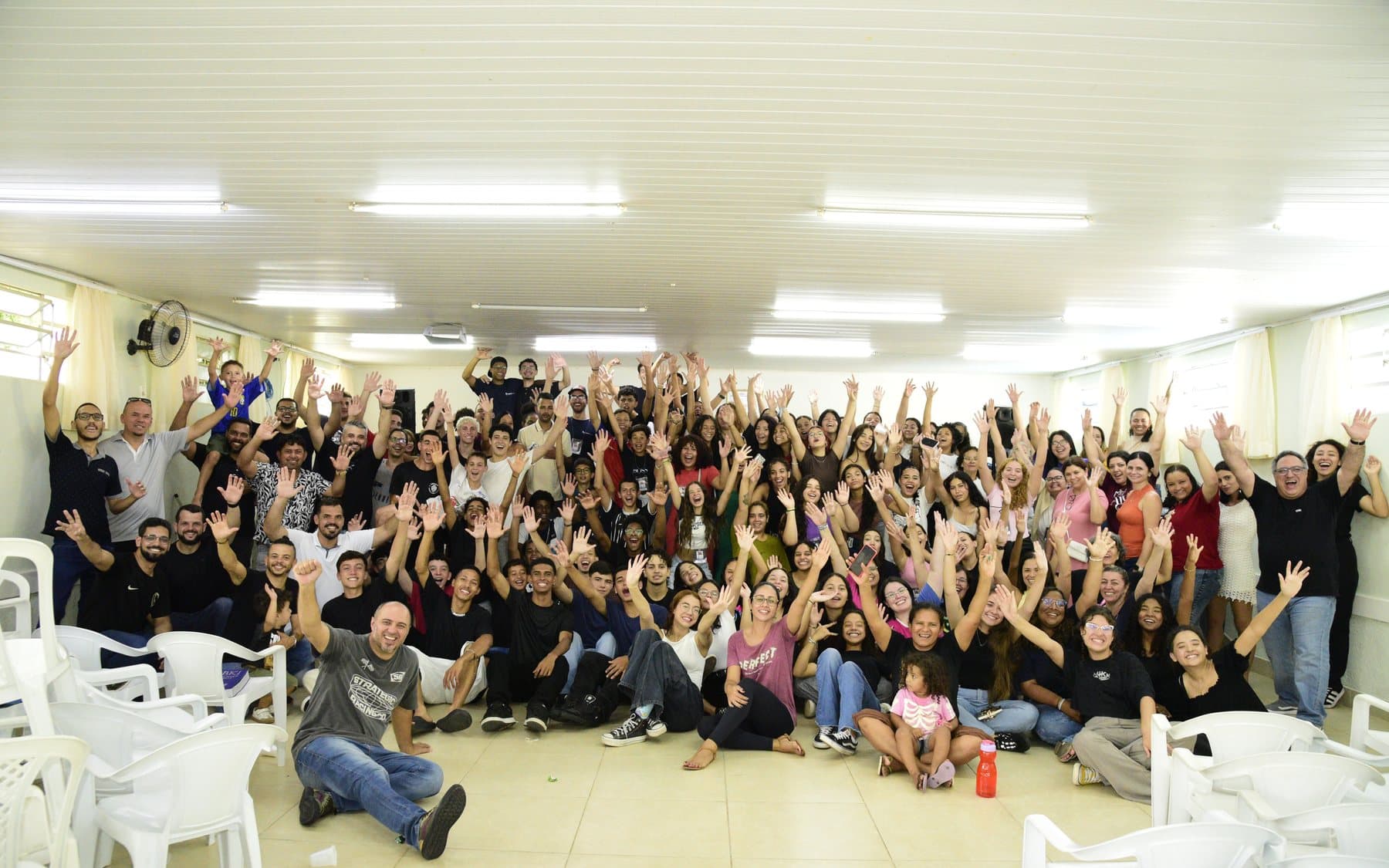 Foto do grupo inteiro do Encontro com Deus, com todos de braços erguidos