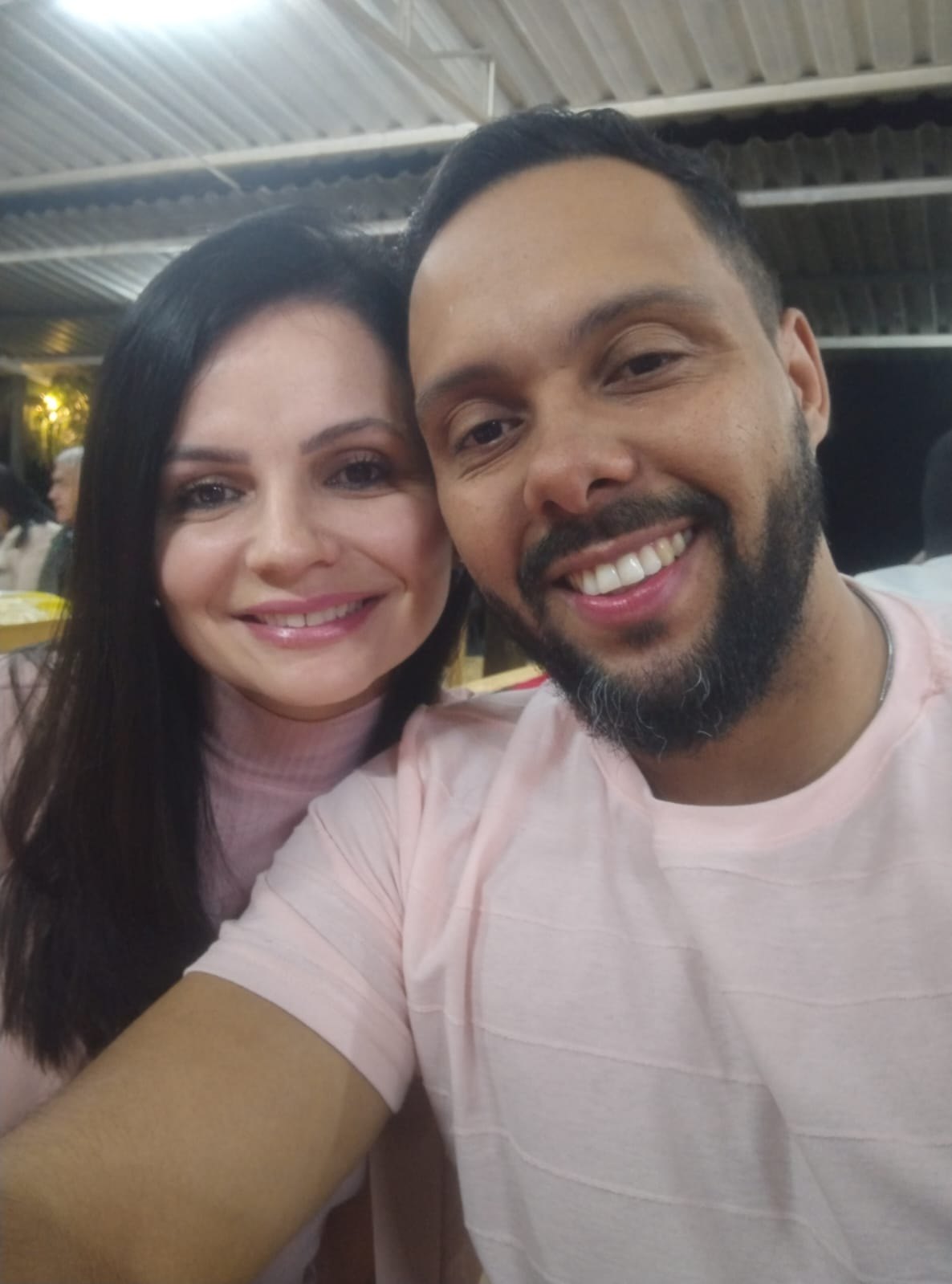 Gustavo e Mariana Pires, líderes de jovens dos Radicais Livres, lado a lado e sorrindo durante um encontro da rede à noite